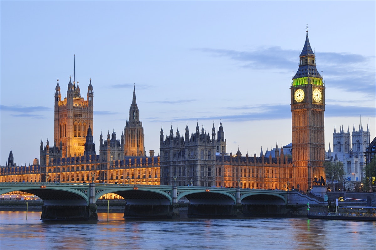 Φωτογραφία του Βρετανικού Κοινοβουλίου, λήψη από τον Τάμεση. Ξεχωρίζει το Μπιγκ Μπεν, φωτισμένο.